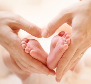 Baby feet in mother hands. Tiny Newborn Baby's feet on female He